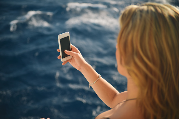 Woman-Using-Smartphone-With-Beautiful-Blue-Ocean Where to Find Free Images Online
